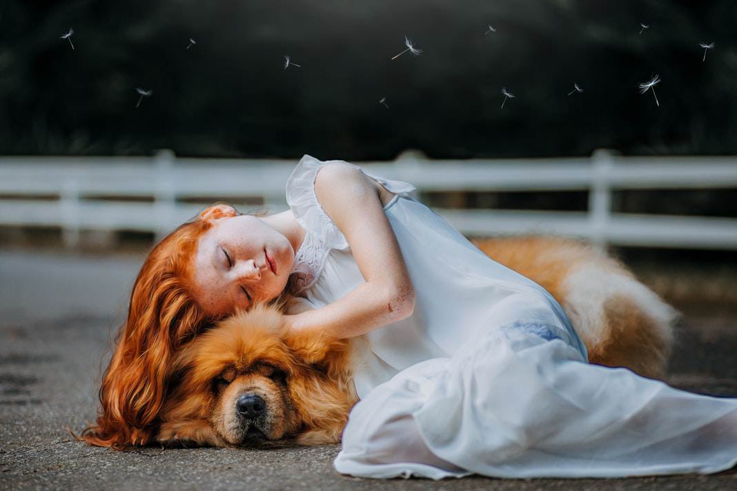 girl sleeping peacefully while holding her dog